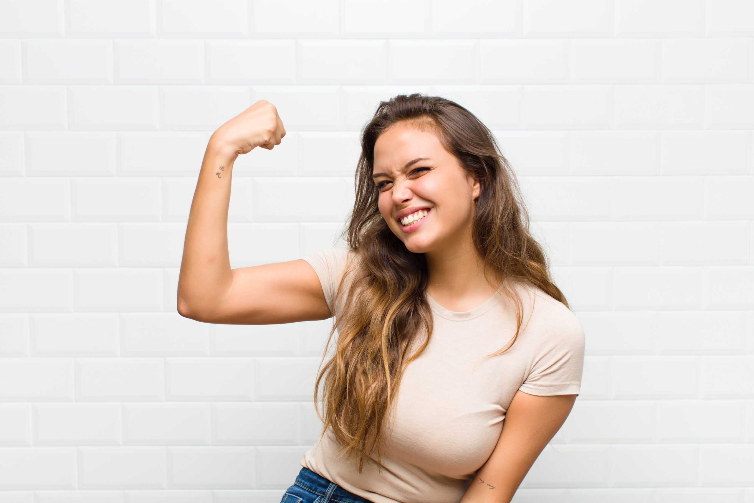 feeling happy, satisfied and powerful, flexing fit and muscular biceps, looking strong after the gym